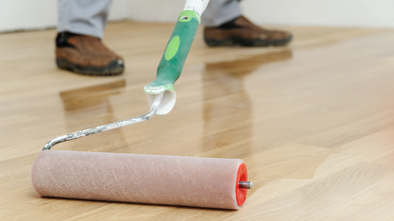 Close-up of a roller applying a clear protective coat during Wood Floor Sanding on a light oak hardwood floor in Tottenham.