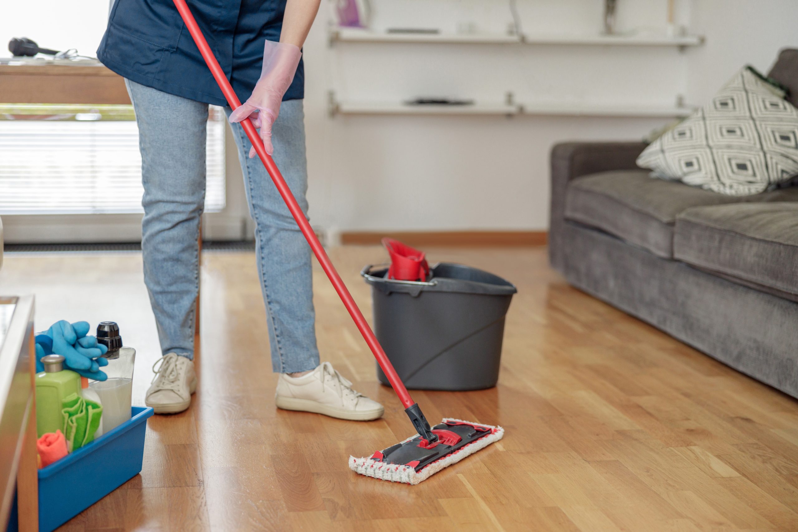 The “Show Home” Clean in Tottenham — European oak engineered wood floor with a satin-lacquer finish being cleaned with a microfibre flat mop; bucket and kit nearby.