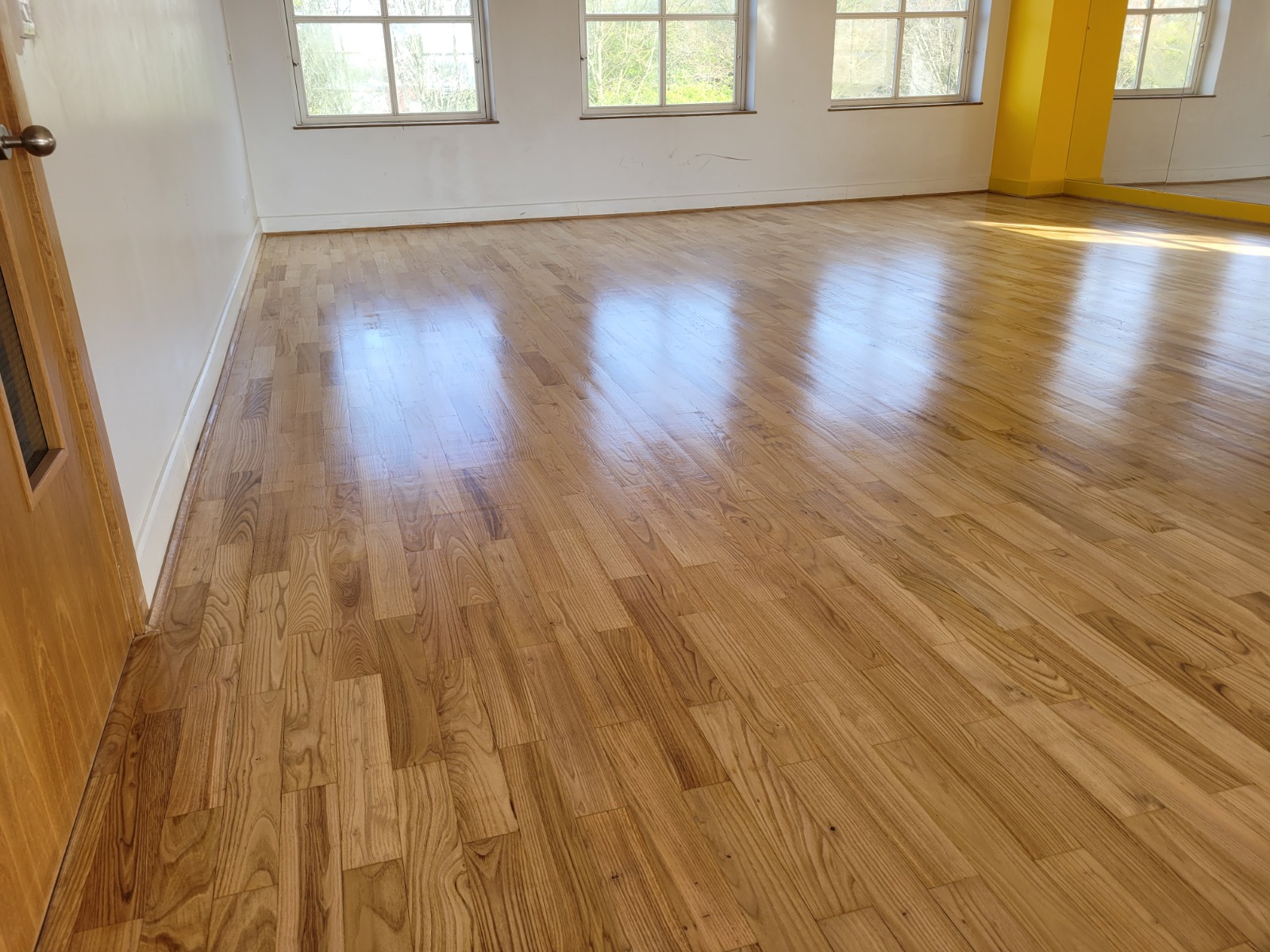The “Show Home” Clean in Tottenham — oak strip hardwood studio floor with a satin lacquer finish, freshly maintained for a clear, non-filming sheen.