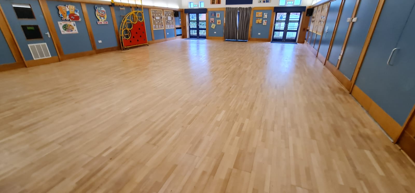 Completed Commercial Floor Sanding in Tottenham on a maple hardwood school hall floor, showing a bright, smooth surface ready for assemblies and activities.