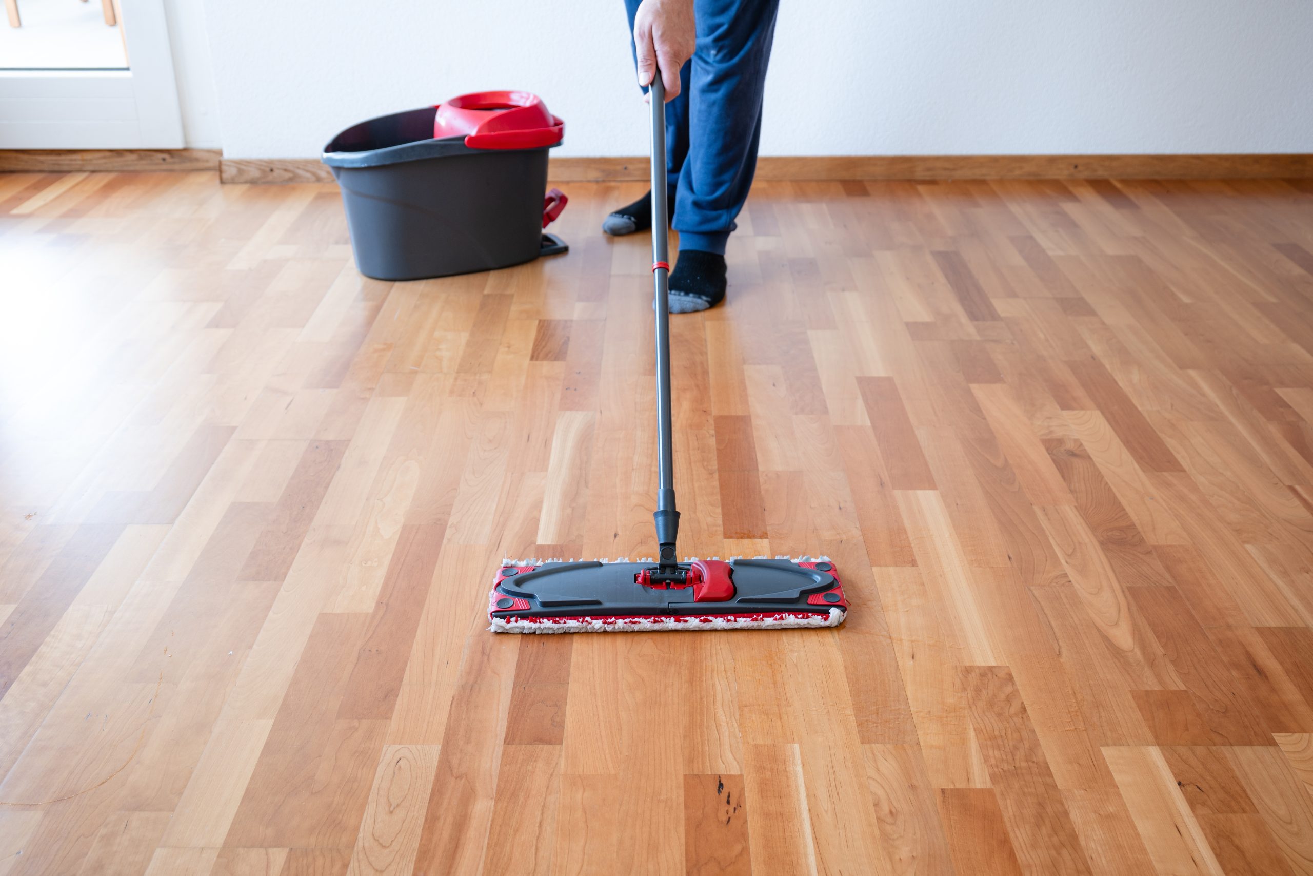 Cleaning an oak hardwood floor in Tottenham after Commercial Floor Sanding, with a microfibre mop gliding over the freshly refinished surface.